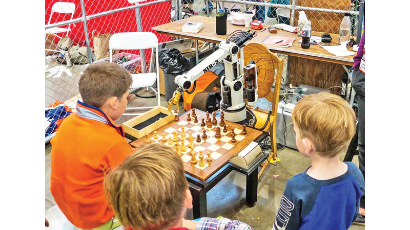 The chess-playing robot with 7-year-old opponent Christopher at the Moscow Chess Open.