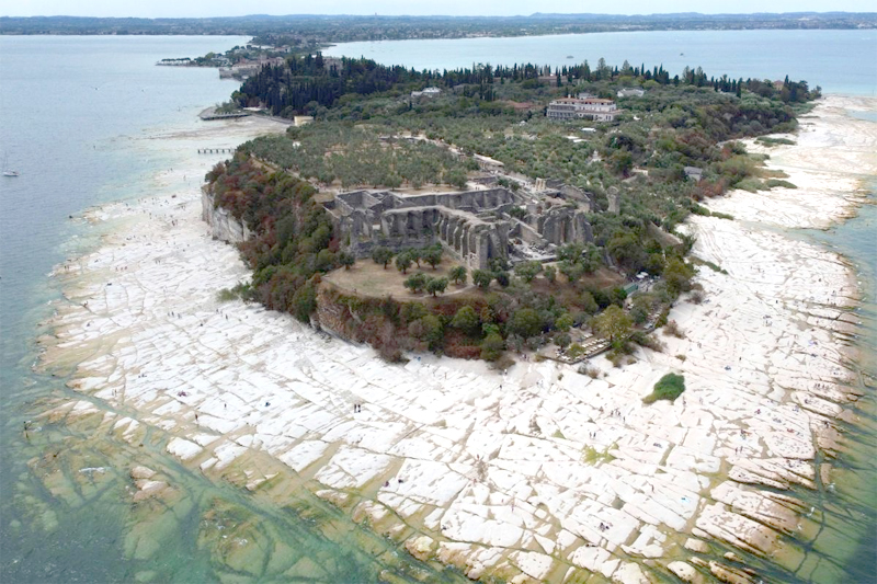 A view of the Sirmione Peninsula, on Lake Garda in Italy, on Friday shows that the water level has dropped critically during the severe drought, resulting in rocks that used to be underwater being exposed around the peninsula.