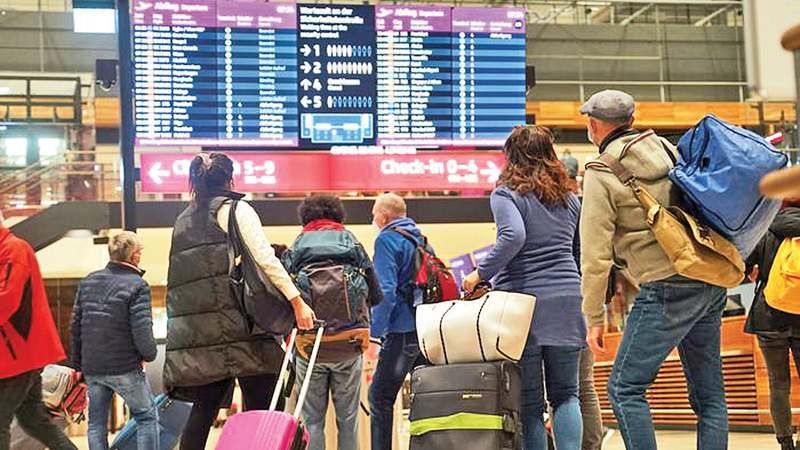 Travellers stand in front of an information board at BER Airport in Berlin, Germany on Saturday. Germany’s incoming Transport Minister is advising people against travelling over Christmas as the country tries to stem the spread of the COVID-19 Omicron variant.