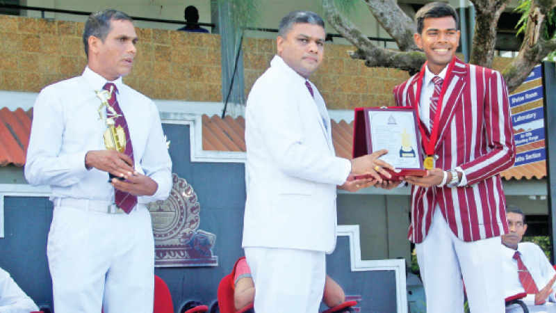 The skipper of the victorious Nalanda cricket team in the 92nd Battle of the Maroons receiving a memento from the principal Thilak Wattuhewa. Picture by Wasitha Patabendige 