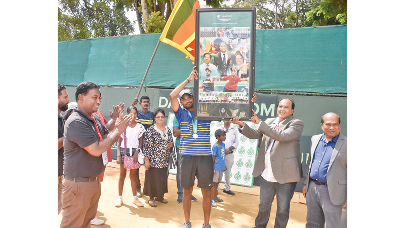 Harshana Godamanna receiving a special memento from the SLT President and Secretary to the Sports Minister Dr. Amal Harsha de Silva.