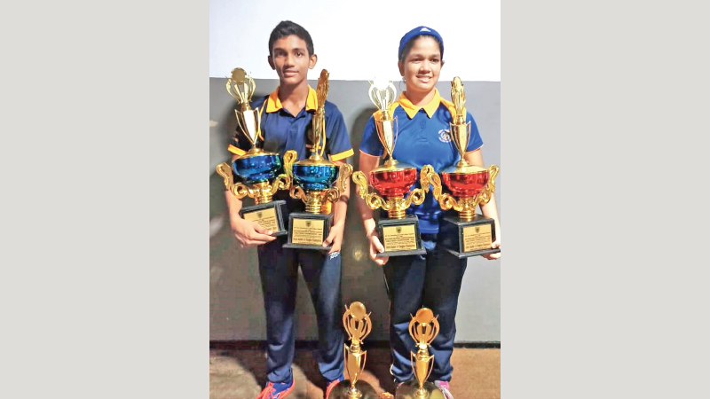 Most outstanding paddlers Janith Batugedera (Royal) and Shenalie Mendis (Musaeus) pose for a picture with their trophies.