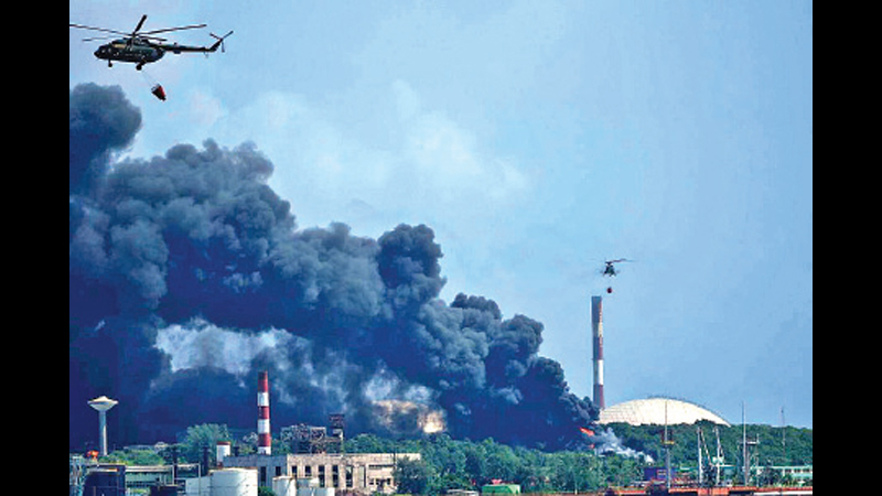Helicopters hauling water fly over the Matanzas Supertanker Base, as firefighters and specialists worked to quell the blaze which began during a thunderstorm in Matazanas, Cuba, on Saturday.