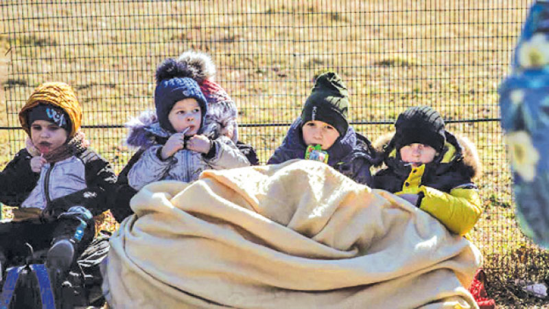 Ukrainian refugee children wait to cross over into Poland via the Medyka border crossing in Shehyni, Ukraine.