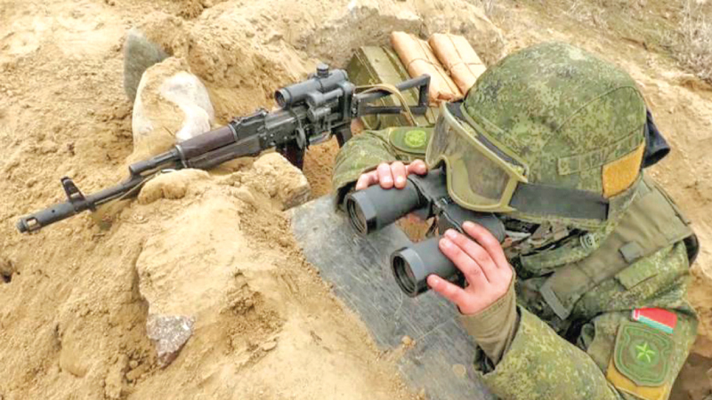 A soldier from Belarus keeps a close watch on the Ukraine-Belarusian border.