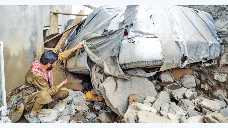 A man looks at his car damaged by the twin earthquakes in Badghis Province in western Afghanistan.