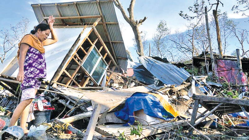 A resident salvages parts of her home damaged due to Typhoon Rai in Talisay, Cebu Province, central Philippines.