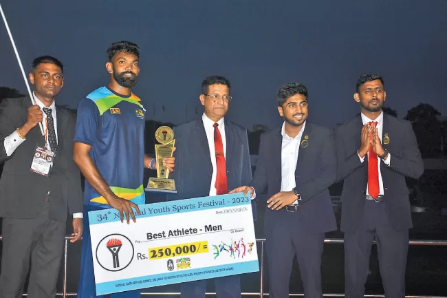 Men’s Best Athlete Janidu Lakvijaya receiving the award from the chief guest.