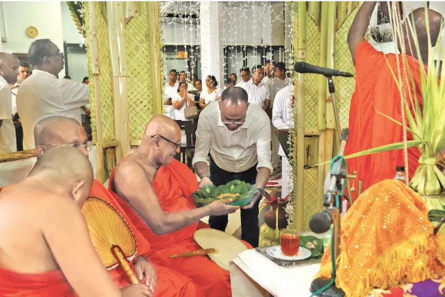 Prof. Harendra Kariyawasam, Chairman and Managing Director of Lake House giving alms to monks participating the all-night pirith chanting ceremony.
