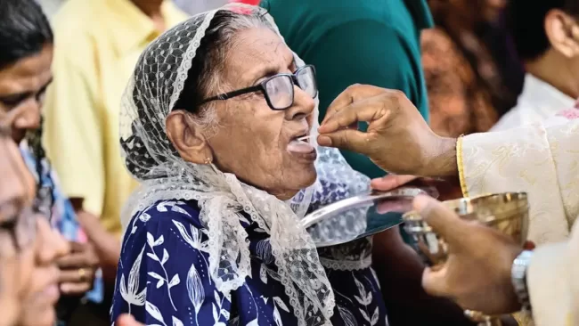  A Catholic priest gives the Holy communion to a Christian devotee at St. Sebastian’s Church in Katuwapitiya, Sri Lanka. 