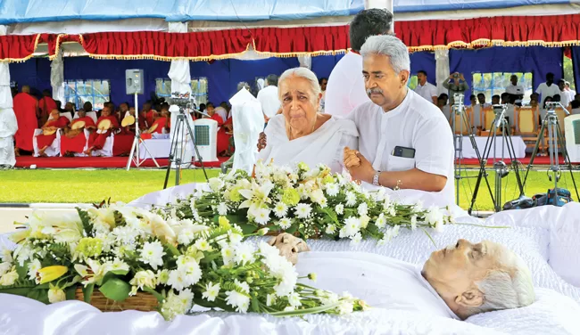 The wife of late Dr. Ariyaratne and his son Dr. Vinya Ariyaratne paying their last respects.